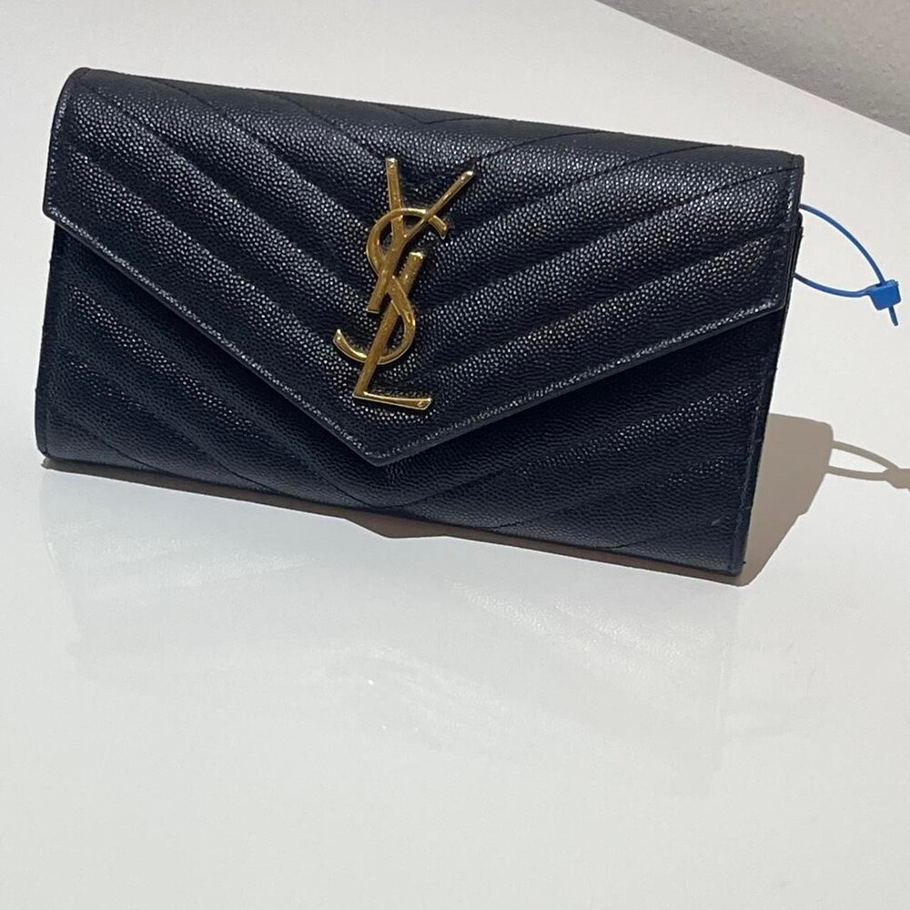 Black quilted leather Saint Laurent envelope wallet with gold logo. This item ha